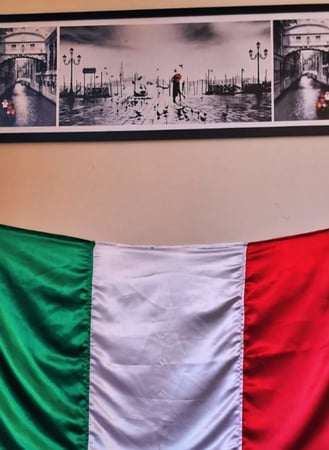 Quadro em preto e branco de Veneza sobre a bandeira da Itália estendida na parede