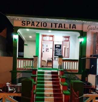 Fachada do Spazio Italia à noite, com a escadaria pintada nas cores da Itália