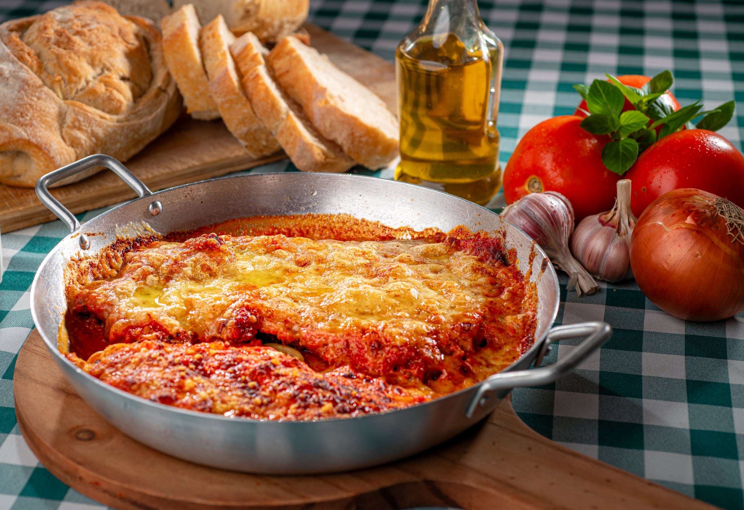 Filé à parmegiana gratinado com molho de tomate, servido na frigideira